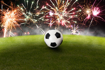 Fussball auf dem Spielfeld vor einem Feuerwerk
