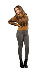 A full-length shot of a Teenager girl with brown sweater suffering from backache for having made an effort over isolated white background