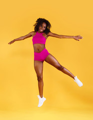 Fototapeta na wymiar Sporty fit black skin woman, athlete makes fitness exercising on dark background.