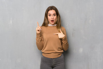 Teenager girl over textured wall with surprise facial expression