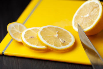 Sliced lemon on a yellow cutting board