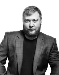 Black and white portrait of a bearded man. Office style, jacket and t-shirt. Isolated on white background