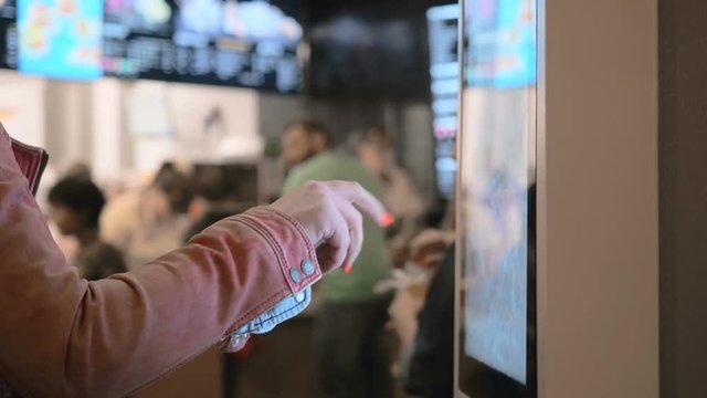 Woman Choosing Food Via Self-Service Machine at Fast Food Restaurant . People Using Self-Service Touch Terminal Makes a Purchase of Food