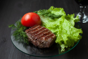 Grilled steak with tomato,  salad and herbs.