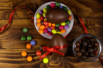 Easter composition with chocolate eggs on wooden background
