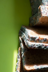 Moldy bread on green background.