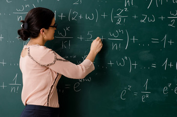 Female teacher standing in front of chalkboard   