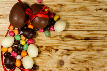 Easter composition with chocolate eggs on wooden background