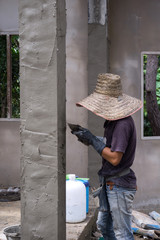 Construction workers plastering building wall
