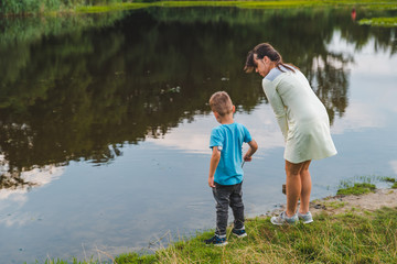 Fototapeta na wymiar mother with son playing near lake water