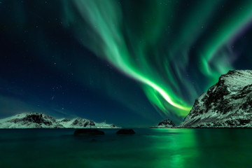 Fototapeta na wymiar Beautiful green Northern Lights at Haukland Beach on the Lofoten Islands in Norway