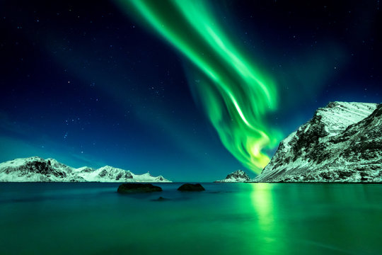 Beautiful green Northern Lights at Haukland Beach on the Lofoten Islands in Norway