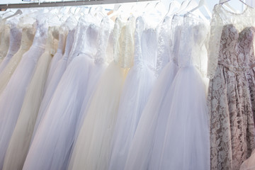 Elegant wedding dStand with many beautiful wedding dresses in the showroom.