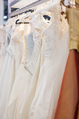 Fototapeta na wymiar Elegant wedding dStand with many beautiful wedding dresses in the showroom.