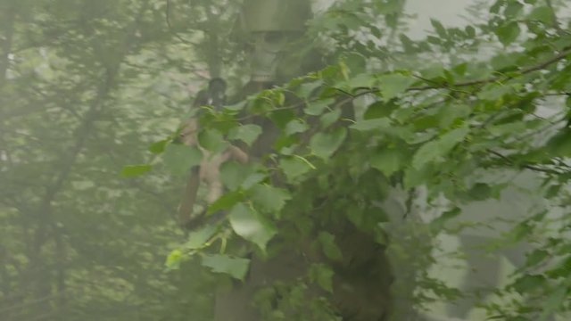Soldiers wearing gas masks and running near a burning building