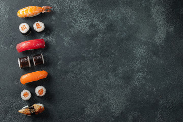Set of sushi and maki on stone table.