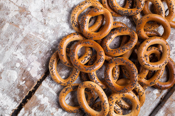 Photo of delicious bagels sprinkled with poppy seeds. Light wooden background