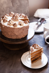 Homemade Kiev cake, dacquoise cake with butter cream and hazelnuts. Gradient  layers in brown shades