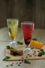 two glasses with colored hot drinks from which steam comes. winter hot seasonal drinks