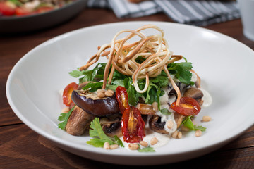 Grilled eggplant salad, tomatoes, mushrooms, cheese sauce, Cecil smoked cheese, fresh herbs. Wooden background