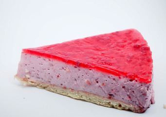 Piece of cake on white background. Cheesecake with raspberry jelly.