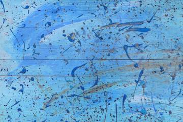 Abstract view of a blue wooden board with paint stains as background, texture