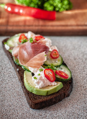 black bread with avocado, cucumber, cheese mass, prosciutto. Avocado bread and egg boiled and rosemary. Different items