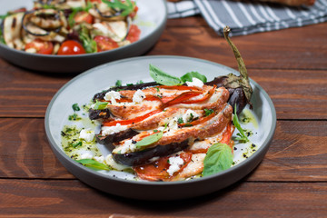 Fan of eggplant, meat stew, tomatoes, cheese, delicious Italian dish. Wooden background