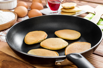 Pan with pancakes and ingredient for cooking pancakes on the table. Top view. Space for text.