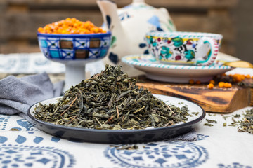 Whole leaf green tea. Dried leafs of natural organic tea on dish.