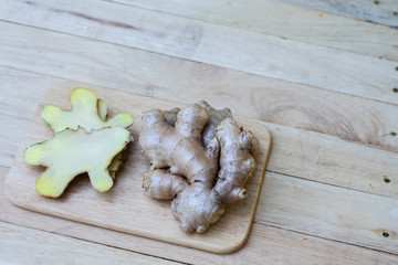 Fresh ginger on wooden chopping board, herb ingredient concept