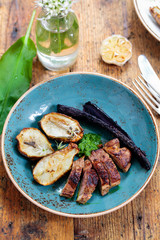Lamb leg fillet with wild garlic puree, roast garlic bulb and jerusalem artichoke