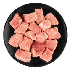 Raw meat is cut into pieces in a black plate. 