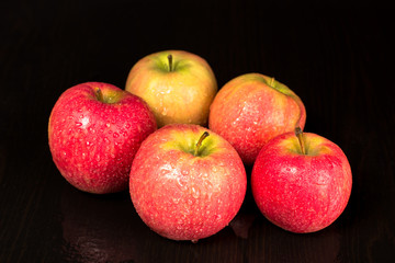 Ripe red apples lie on the table, black background