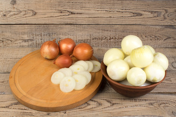 onion in a plate, onion rings on a cutting board. country style.