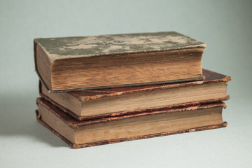 three old books on blue background, aged books, yellow paper pages