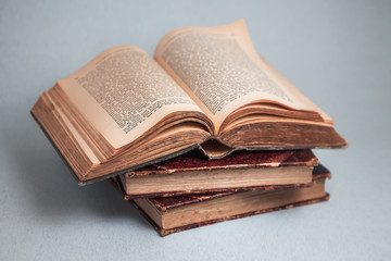 old books, open aged book, ancient paper pages, blurred text, blue background