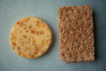 Cheese with apricots and crackers on blue background 