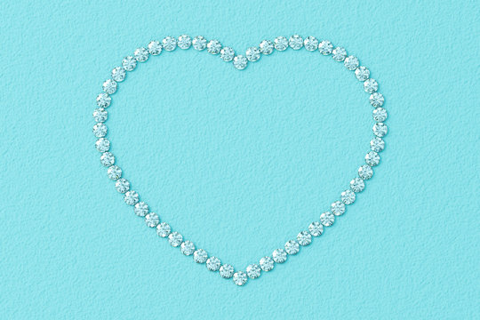 Heart-shaped frame made of small diamonds on turquoise textured background