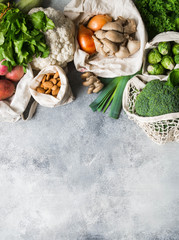 Healthy vegan ingredients for cooking. Various clean wholesome vegetables and herbs in woven bags. Products from the market without plastic. Zero waste concept flat lay. Copy space