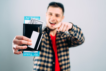 Man in shirt with plane tickets credit card and passport in hand