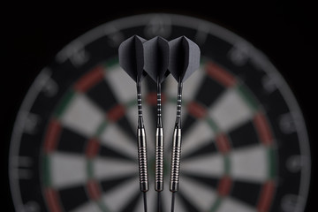 3 darts on dartboard background. dart board blurred