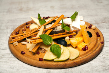 wooden plate with feta cheese grapes nuts and mint