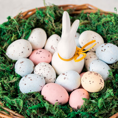 Easter concept.bunny in a basket with easter colored eggs.