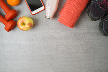 Fitness background with dumbbells, protein shake, smartphone and towel.
