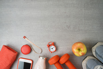 Fitness background with dumbbells, protein shake, smartphone and towel.