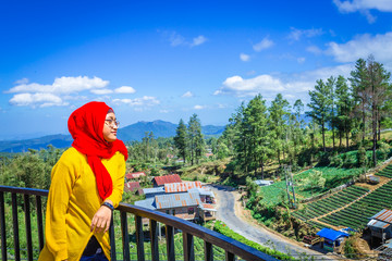 Fototapeta na wymiar A Muslim teen enjoying the view of beautiful landscape in Indonesia