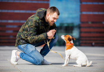 man with his dog, Jack Russell Terrier, on the city street