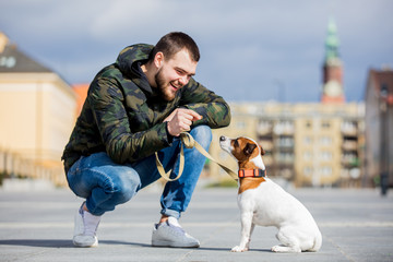 man with his dog, Jack Russell Terrier, on the city street
