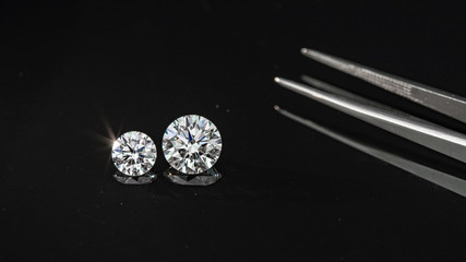 Compared 1.00 and 2.50 carat size diamonds on black background